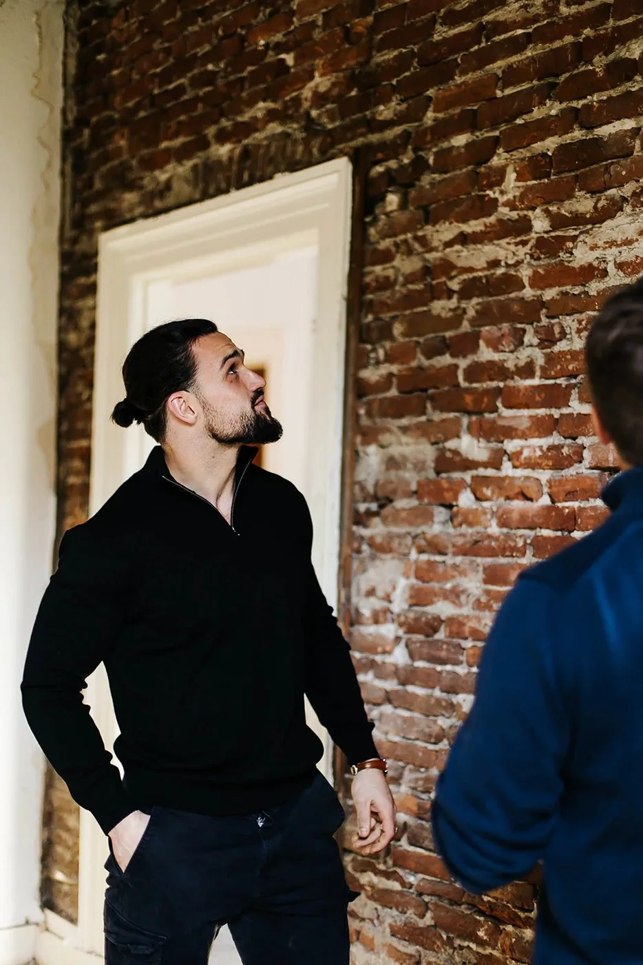 Adviseur inspecteert een muur tijdens de opname op locatie